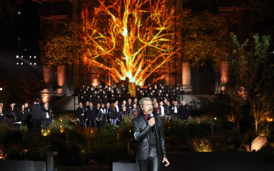 Un chanteur devant le chœur et la projection d’un arbre lumineux