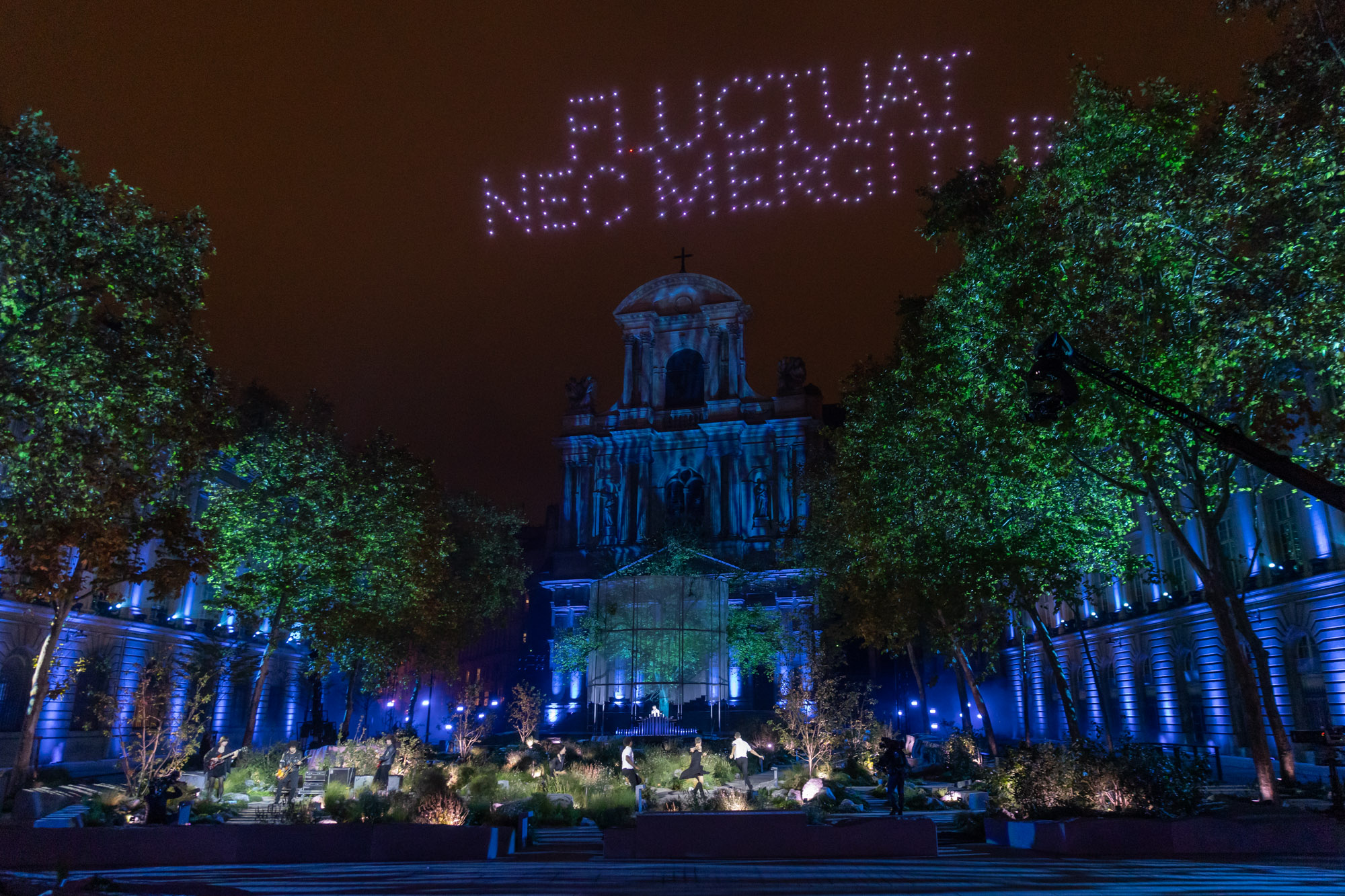 La cérémonie éclairée en bleu sous les mots Fluctuat nec mergitur