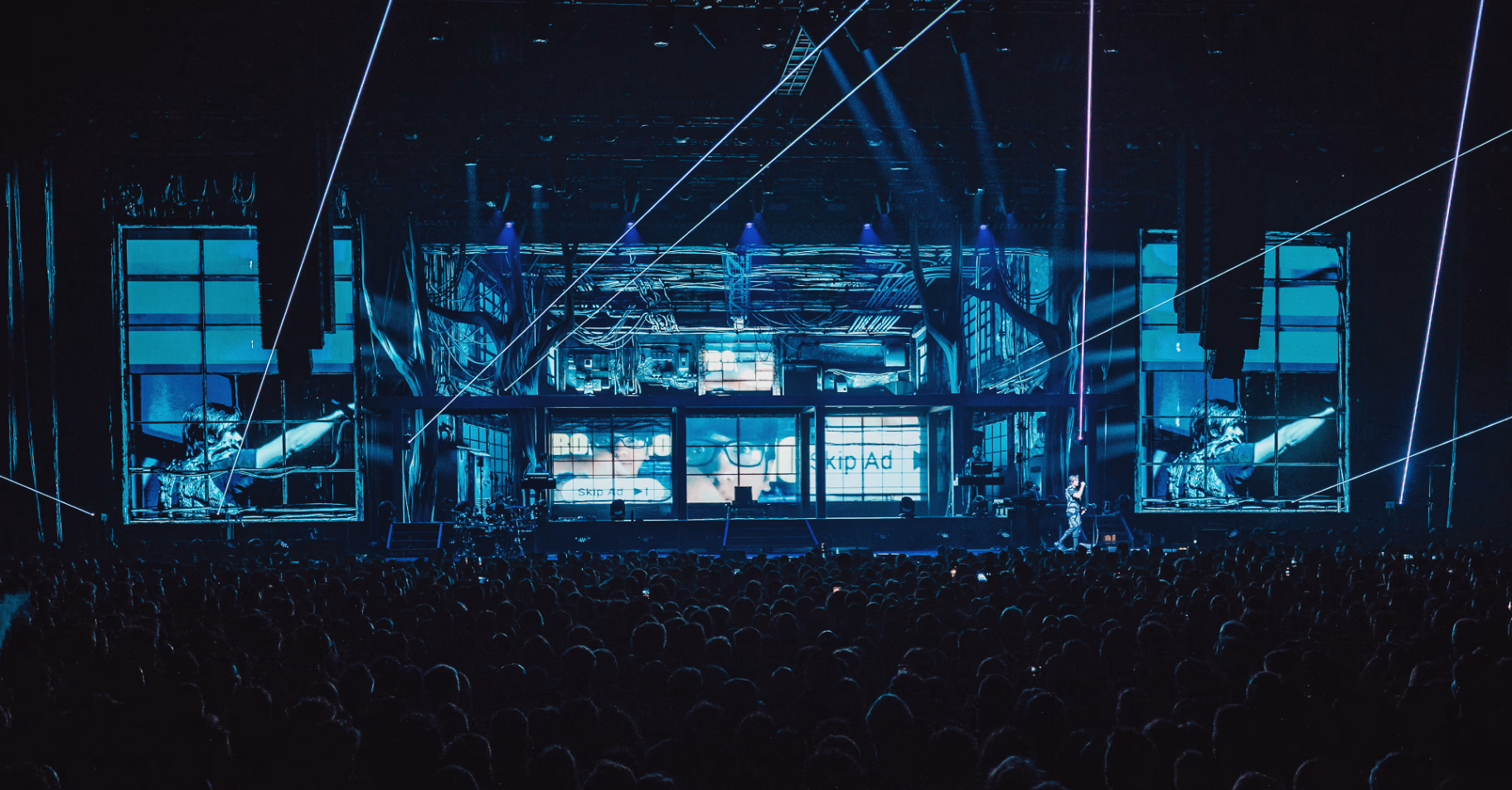 Lasers traversant la salle devant le décor bleu