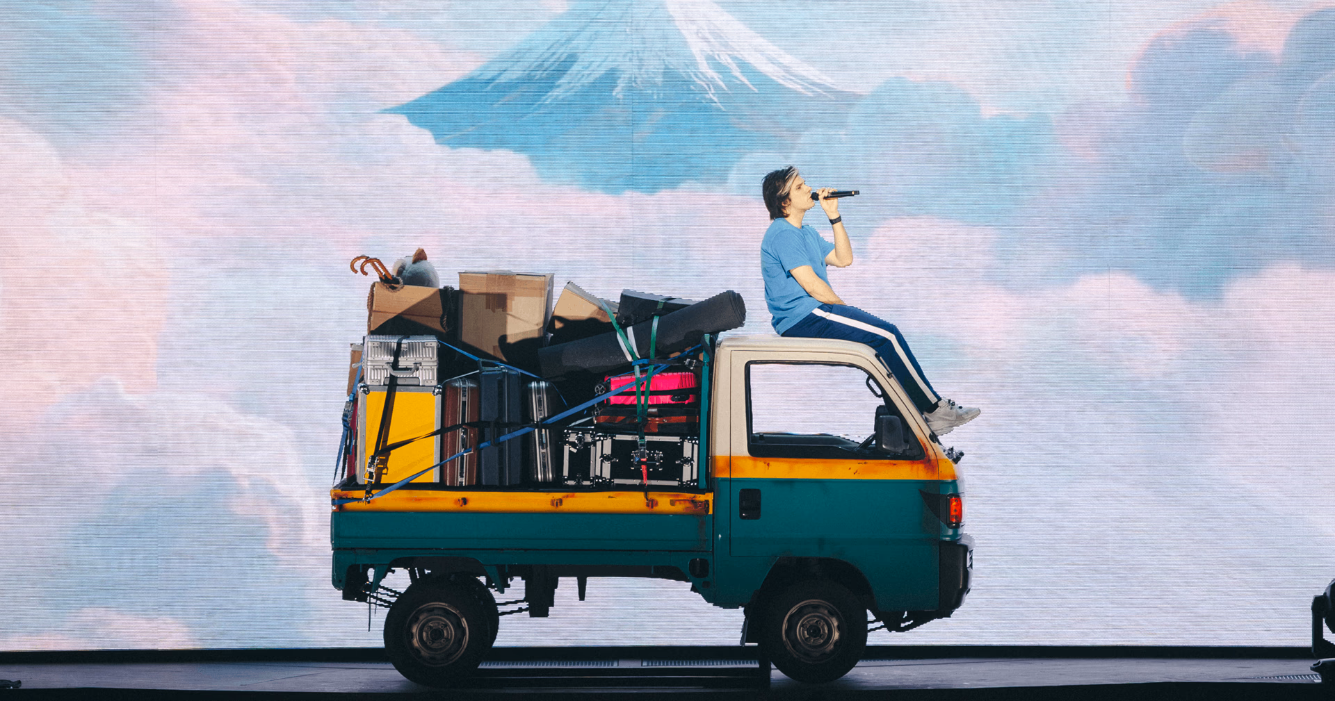 Orelsan sur une camionnette devant un paysage du mont Fuji