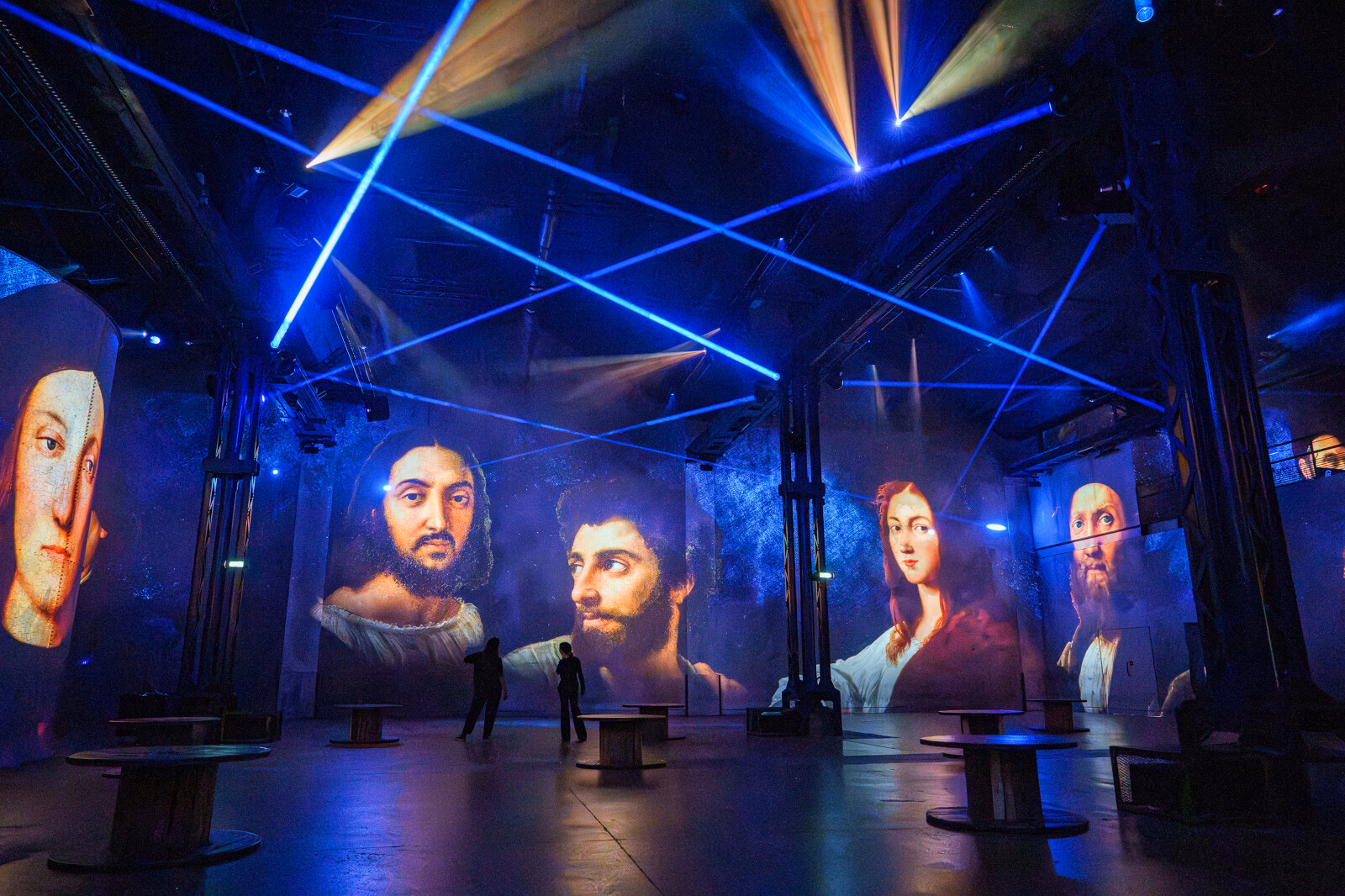 Portraits projetés sous des faisceaux bleus et dorés