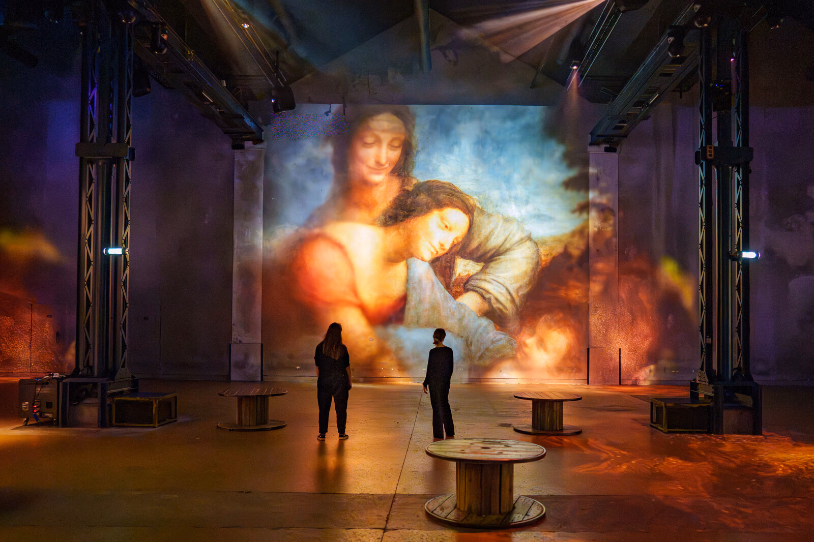 Peinture projetée dans des tons chauds devant deux visiteurs